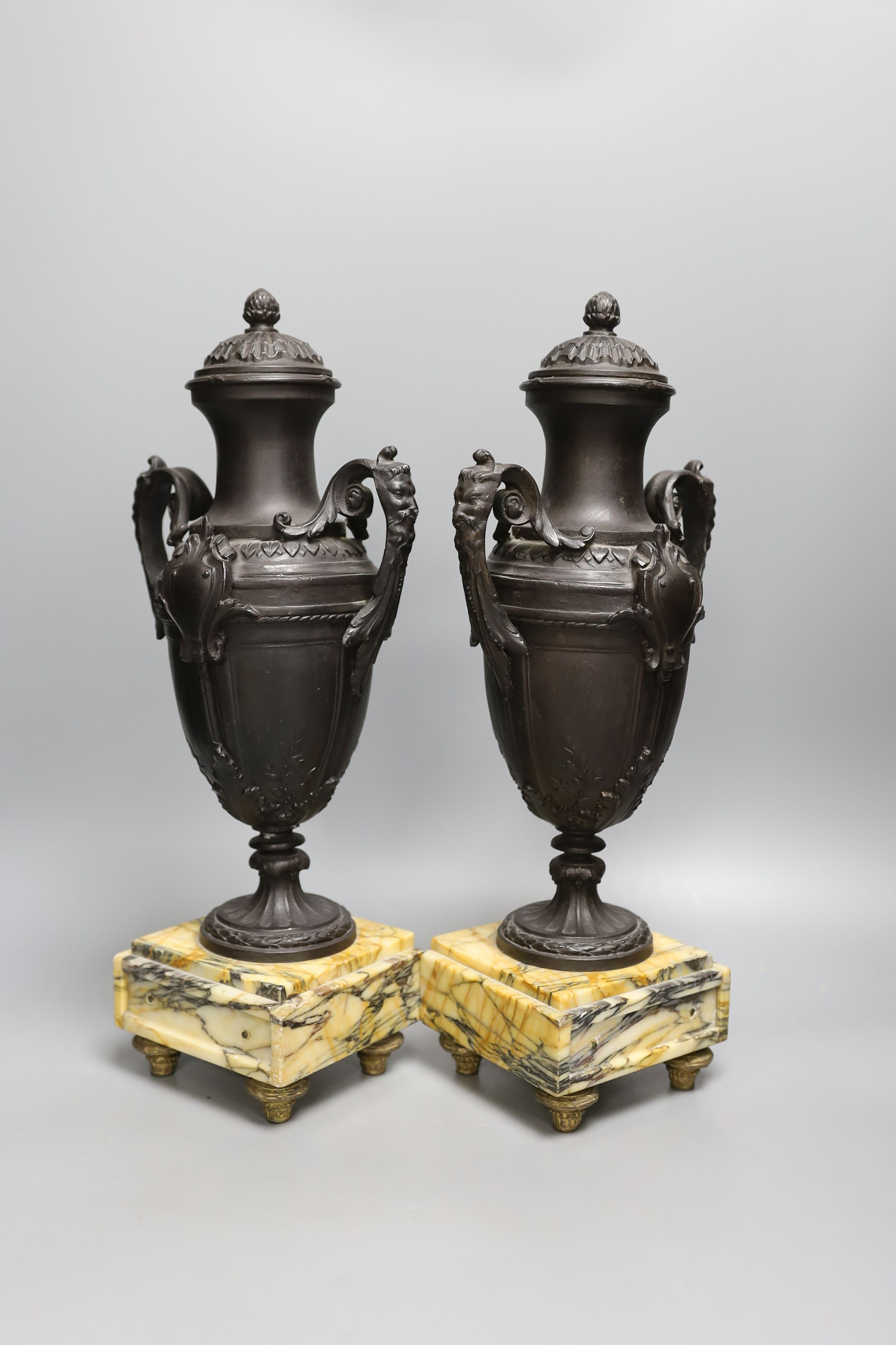 A pair of bronzed spelter urns on marbled base - 40cm tall